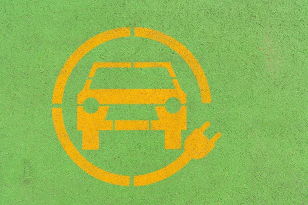 Κίτρινο Ηλεκτρικό Αυτοκίνητο Σύμβολο Στην Πράσινη Άσφαλτο Χώρος Στάθμευσης Ηλεκτρικών — Φωτογραφία Αρχείου
