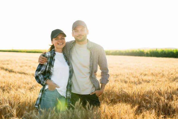 Couple Farmers Plaid Shirts Caps Stand Embracing Agricultural Field Wheat — Fotografia de Stock