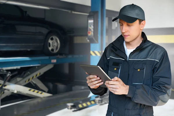 Serviceman Digital Tablet Background Column Lift Car Service — Stock fotografie