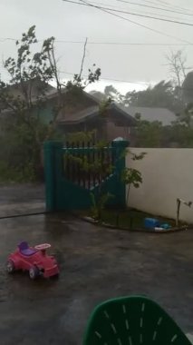 Yerleşim bölgesinde güçlü rüzgarlar estiren yağmurun videosu.