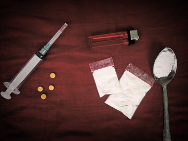 Koyu arkaplanda enjeksiyon, kaşık, uyuşturucu, çakmak ve metamfetamin üst görünümü