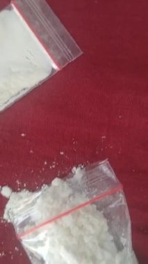 Kırmızı zemin üzerinde enjeksiyon, kaşık, uyuşturucu, çakmak ve metamfetamin videosu
