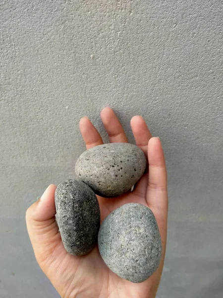 stones in hand on gray background