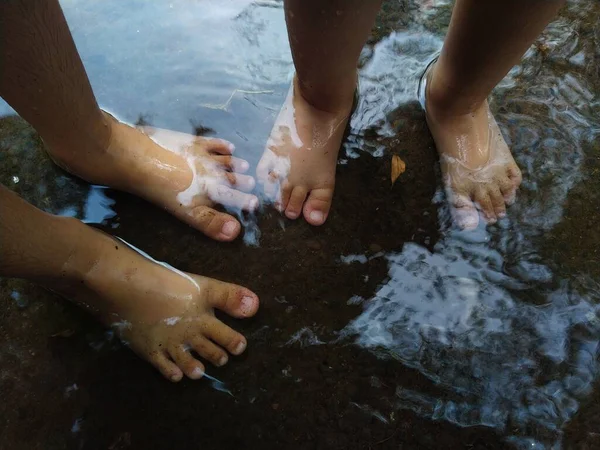 Girl\'s feet and wet water on the sea background