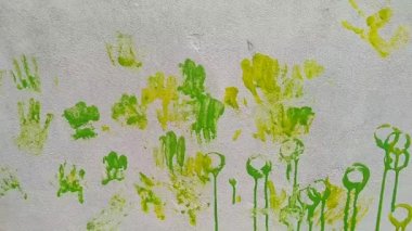 Çocukların beyaz duvarda oynadığı renkli boya pulları.