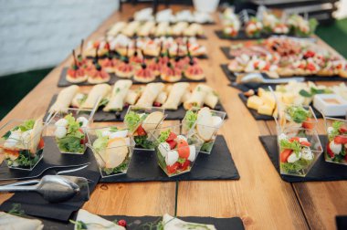 Soğuk atıştırmalıklar, et ve salatalarla dolu açık büfe masası.