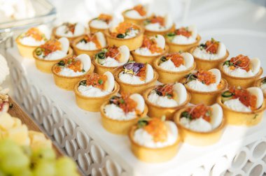 Soğuk atıştırmalıklar, et ve salatalarla dolu açık büfe masası.