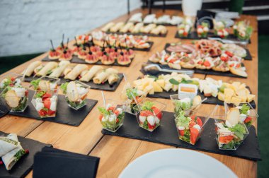 Soğuk atıştırmalıklar, et ve salatalarla dolu açık büfe masası.