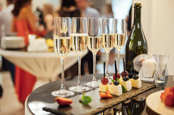 Szklanki z szampanem i owocami na stole w formie bufetu w restauracji lub w hotelowym lobby — Zdjęcie stockowe