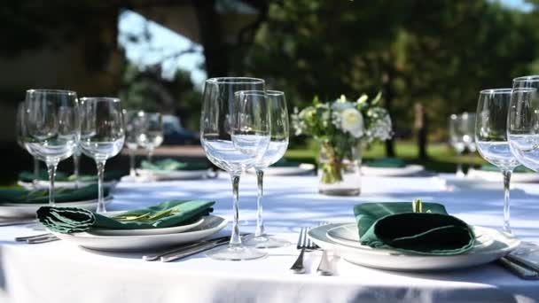 Outdoor banquet table set up served dinner tableware and silverware. Wide footage. — Stock Video