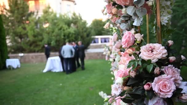 Elegante arco de boda con flores frescas, jarrones en el fondo de las personas — Vídeos de Stock