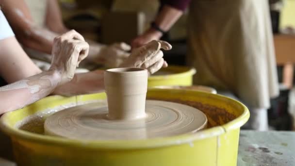 Close-up tiro de copo de cerâmica girando na roda de cerâmica e mãos moldando argila — Vídeo de Stock