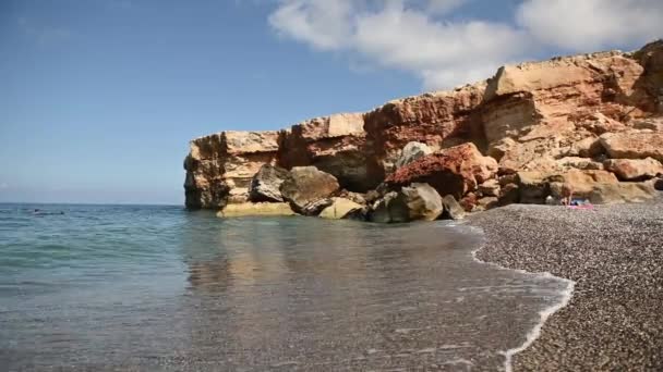 Rochas maciças afundam na água em uma praia de seixos — Vídeo de Stock