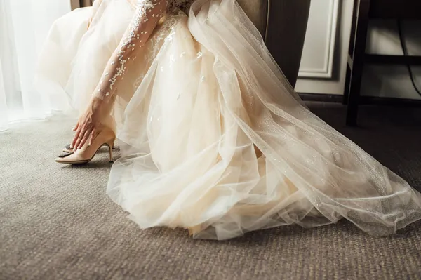 Nevěsta s krajkovými šaty dává na její svatební boty a narovnává je s rukou — Stock fotografie