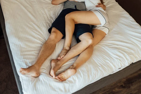 Picioarele unui cuplu heterosexual tânăr care se relaxează în pat. — Fotografie, imagine de stoc