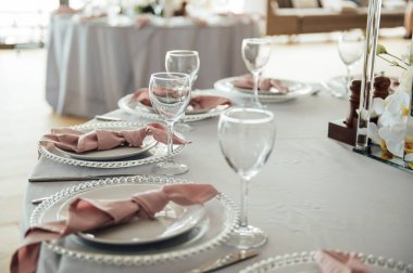 Lüks restoran. Lüks içecekler, beyaz masalar, misafirler için servis tabakları ve bardaklar.
