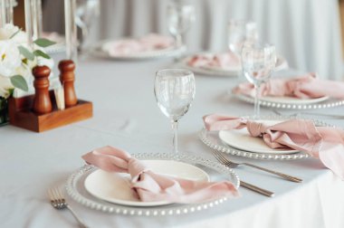 Lüks restoran. Lüks içecekler, beyaz masalar, misafirler için servis tabakları ve bardaklar.