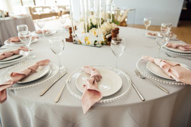 Lüks restoran. Lüks içecekler, beyaz masalar, misafirler için servis tabakları ve bardaklar.