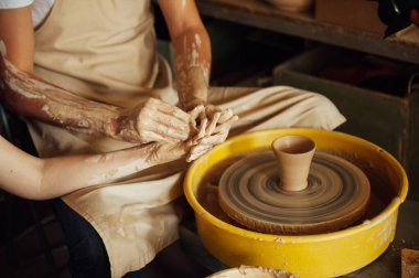Birbirine aşık bir çift çömlek atölyesinde ortak bir fincan yaratıyor. Potter çömlek çarkında seramik demlik yapıyor.