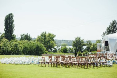 Yeşil çimlerde, tahta sandalyelerde ve taze çiçeklerde inanılmaz güzel bir açık hava töreni. Düğün günü.