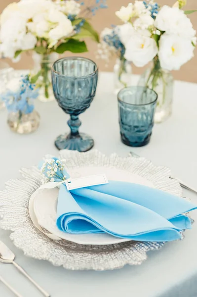 Свадебные столы для гостей с голубой скатертью. Украшенные премиум-очками и цветами — стоковое фото