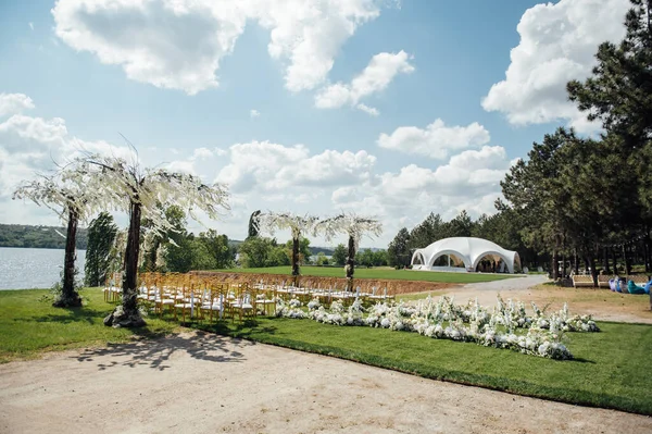 Arco de prêmio de cerimônia de casamento de recém-casados na margem do rio com árvores de wisteria — Fotografia de Stock