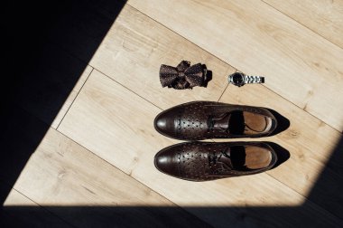 Modern erkek aksesuarlarını kapatın. Siyah papyon, deri ayakkabı ve saat.