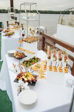 Sandviç, kanepe ve kekler festival masasında. Çok çeşitli atıştırmalıklar.