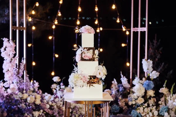 꽃 이 많이 피고 커다란 웨딩 케이크가 있는 현대의 아름다운 웨딩 아치. — 스톡 사진