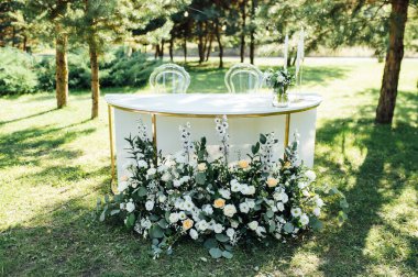 Dışarıda çok güzel bir tören. Ormanda klasik düğün. Çiçekli metal kemer.