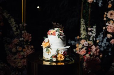 Çiçekli güzel bir düğün kemeri ve büyük bir düğün pastası..