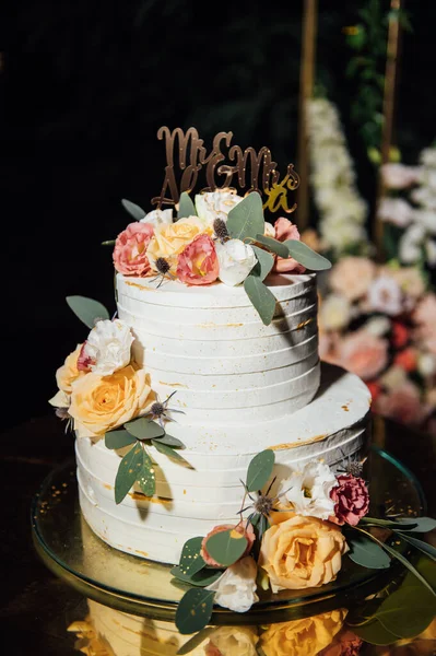 漂亮的婚礼拱门，有鲜花和一个大的结婚蛋糕. — 图库照片
