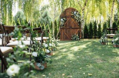 Açık hava düğünü için güzel bir yer. Büyük ahşap bir kapı ve bir sürü çiçekle süslenmiş kemer..