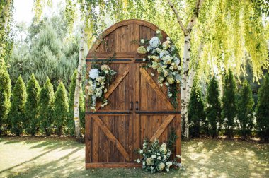 Açık hava düğünü için güzel bir yer. Büyük ahşap bir kapı ve bir sürü çiçekle süslenmiş kemer..