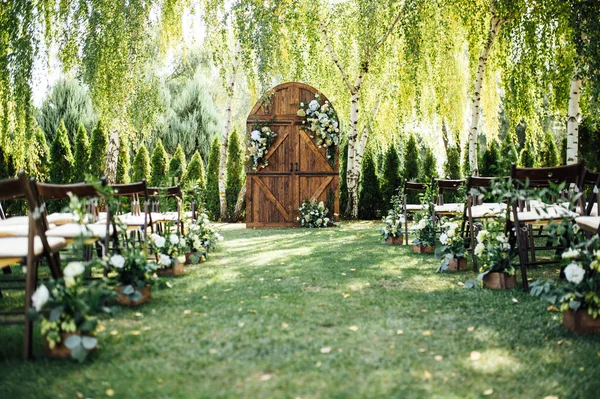 屋外結婚式のための美しいエリア。アーチ多くの花と大きな木製のドアで飾ら. — ストック写真