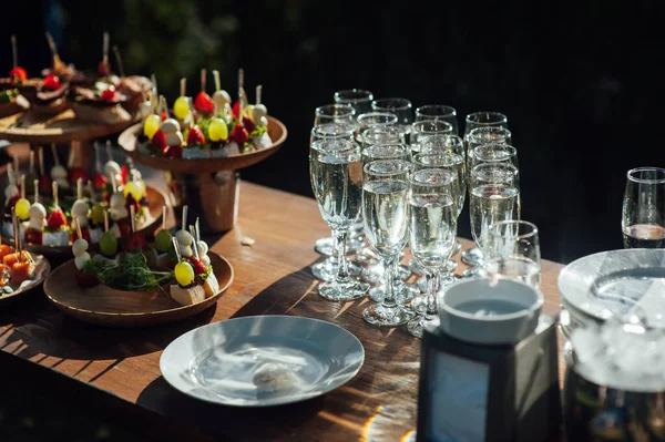 Tafel van diverse snacks, sandwiches, aardbeien en champagneglazen. Buffet voor bruiloftsgasten — Stockfoto