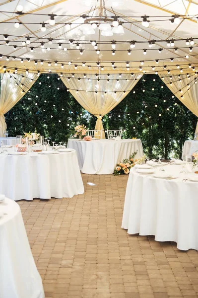 Večerní dekorace svatební oslavy. Stoly pro hosty s věncem a lampami — Stock fotografie