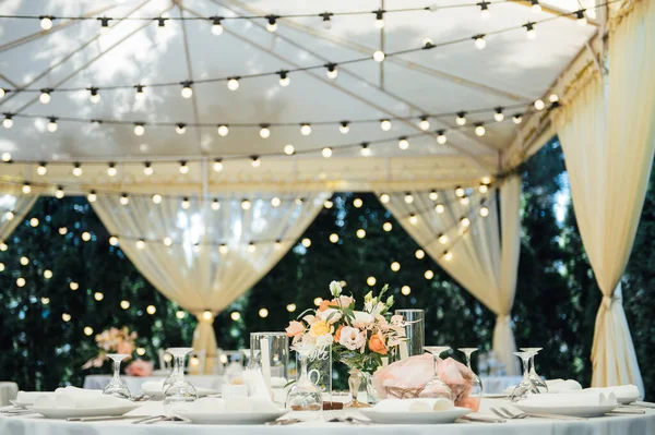 Вечернее украшение свадебной вечеринки. Столы для гостей с гирляндой и лампами — стоковое фото