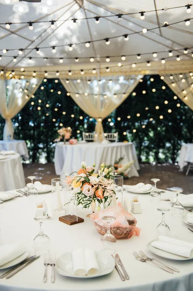 Βραδινή διακόσμηση γαμήλιου πάρτι. Τραπέζια για επισκέπτες με γιρλάντα και λάμπες — Φωτογραφία Αρχείου