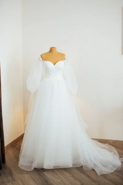 花嫁のドレスは窓にかかっている。花嫁と女性の靴の優しい花束が窓辺に立っています — ストック写真