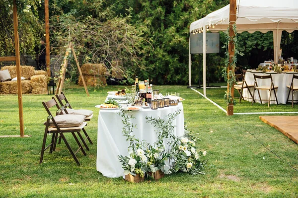 Bröllop. Bankett. Stolar och runda bord för gäster, serveras med bestick. — Stockfoto