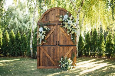 Açık hava düğünü için güzel bir yer. Büyük ahşap bir kapı ve bir sürü çiçekle süslenmiş kemer..