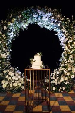 Çiçekli güzel düğün pastası ve büyük bir düğün kemeri..