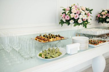 Masada konuklar için çok çeşitli atıştırmalıklar var. Karides, haşlanmış domuz eti, çeşitli et ve diğer ürünler.