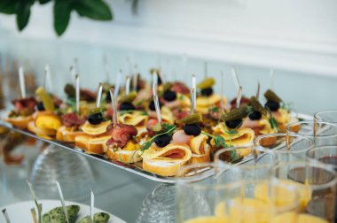 Masada konuklar için çok çeşitli atıştırmalıklar var. Karides, haşlanmış domuz eti, çeşitli et ve diğer ürünler.