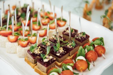 Masada konuklar için çok çeşitli atıştırmalıklar var. Karides, haşlanmış domuz eti, çeşitli et ve diğer ürünler.