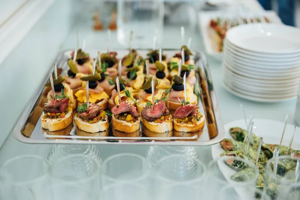 Masada konuklar için çok çeşitli atıştırmalıklar var. Karides, haşlanmış domuz eti, çeşitli et ve diğer ürünler.