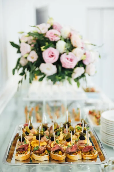 A wide variety of snacks on the table for guests. Shrimp, boiled pork, various types of meat and other products — Stock Photo, Image