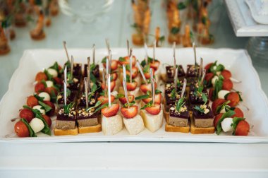 Masada konuklar için çok çeşitli atıştırmalıklar var. Karides, haşlanmış domuz eti, çeşitli et ve diğer ürünler.