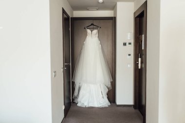 Törenden önce, omuzlarında beyaz gelinlik.